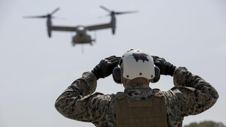 U.S. Marine Corps Lance Cpl. Mackinnly Lewis, a landing support specialist with Combat Logistics Battalion 2, Special Purpose Marine Air-Ground Task Force-Crisis Response-Africa, guides an MV-22B Osprey during a helicopter support team exercise at Naval Station Rota, Spain, July 6, 2016. This training prepares Marines to deliver and recover supplies and equipment quickly and efficiently in potential future missions around Europe and Africa.