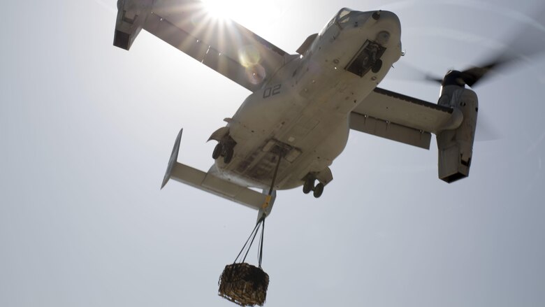 An MV-22B Osprey with Marine Medium Tiltrotor Squadron 263, Special Purpose Marine Air-Ground Task Force-Crisis Response-Africa, transports a 1,098 pound pallet of Meals, Ready to Eat during a helicopter support team exercise at Naval Station Rota, Spain, July 6, 2016. External lift training prepares the Marines to efficiently attach cargo to the aircraft and helps qualify air crew in the mission-essential task of rapid insertion and extraction in a possible crisis response scenario.