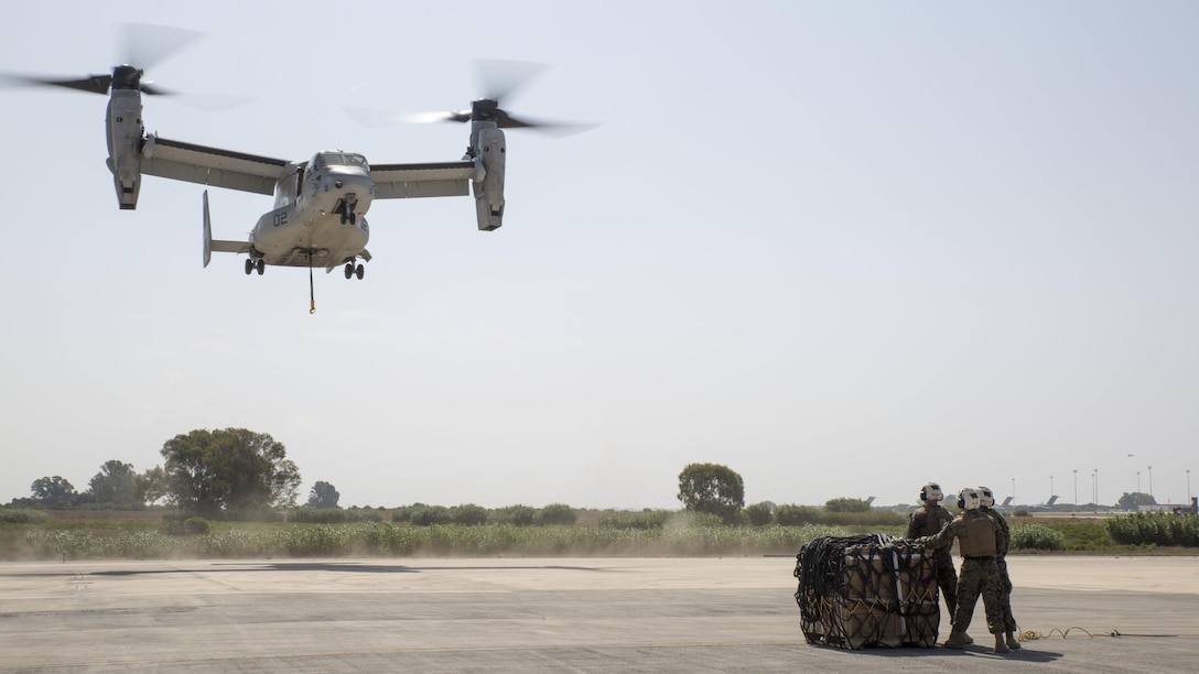 Landing support specialists with Combat Logistics Battalion 2, Special Purpose Marine Air-Ground Task Force-Crisis Response-Africa, await the arrival of an MV-22B Osprey during a helicopter support team exercise at Naval Station Rota, Spain, July 6, 2016. This training prepares Marines to deliver and recover supplies quickly and efficiently in potential future missions across Europe and Africa.