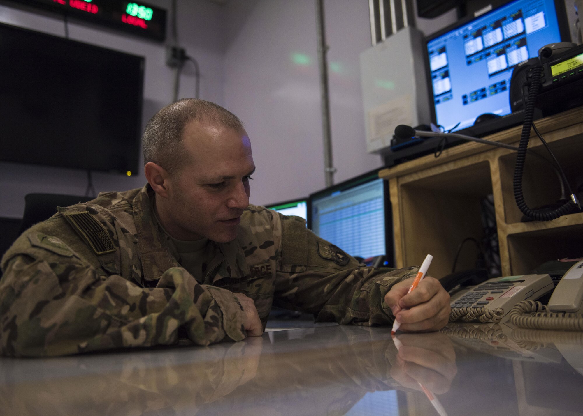 Tech. Sgt. Alexander Mears, 455th Air Expeditionary Wing senior command post controller, marks a weather warning checklist, July 11, 2016, Bagram Airfield, Afghanistan. The weather warning checklist helps ensure command post personnel notify all flightline personnel and aircraft if there happens to be safety concerns. (U.S. Air Force photo by Senior Airman Justyn M. Freeman)