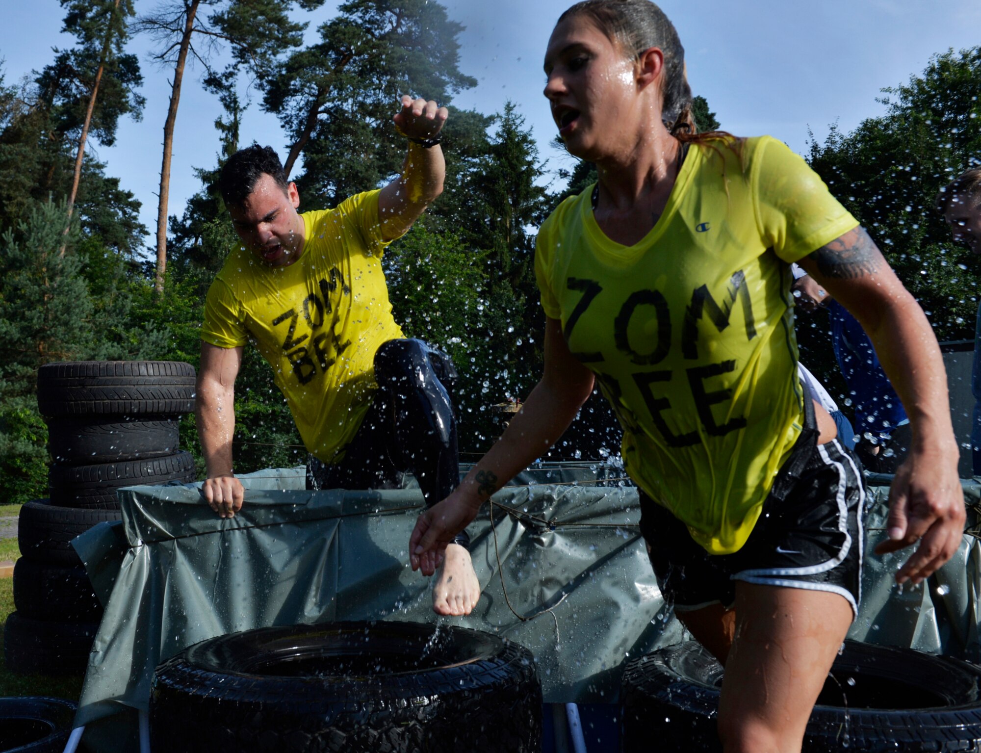 Mudless Mudder participants climb out of a pool of water, July 8, 2016 at Ramstein Air Base, Germany. The five-kilometer obstacle course contained 15 events including monkey bars, a rope walk, tire carry and pallet climb. (U.S. Air Force photo/ Senior Airman Nesha Humes)