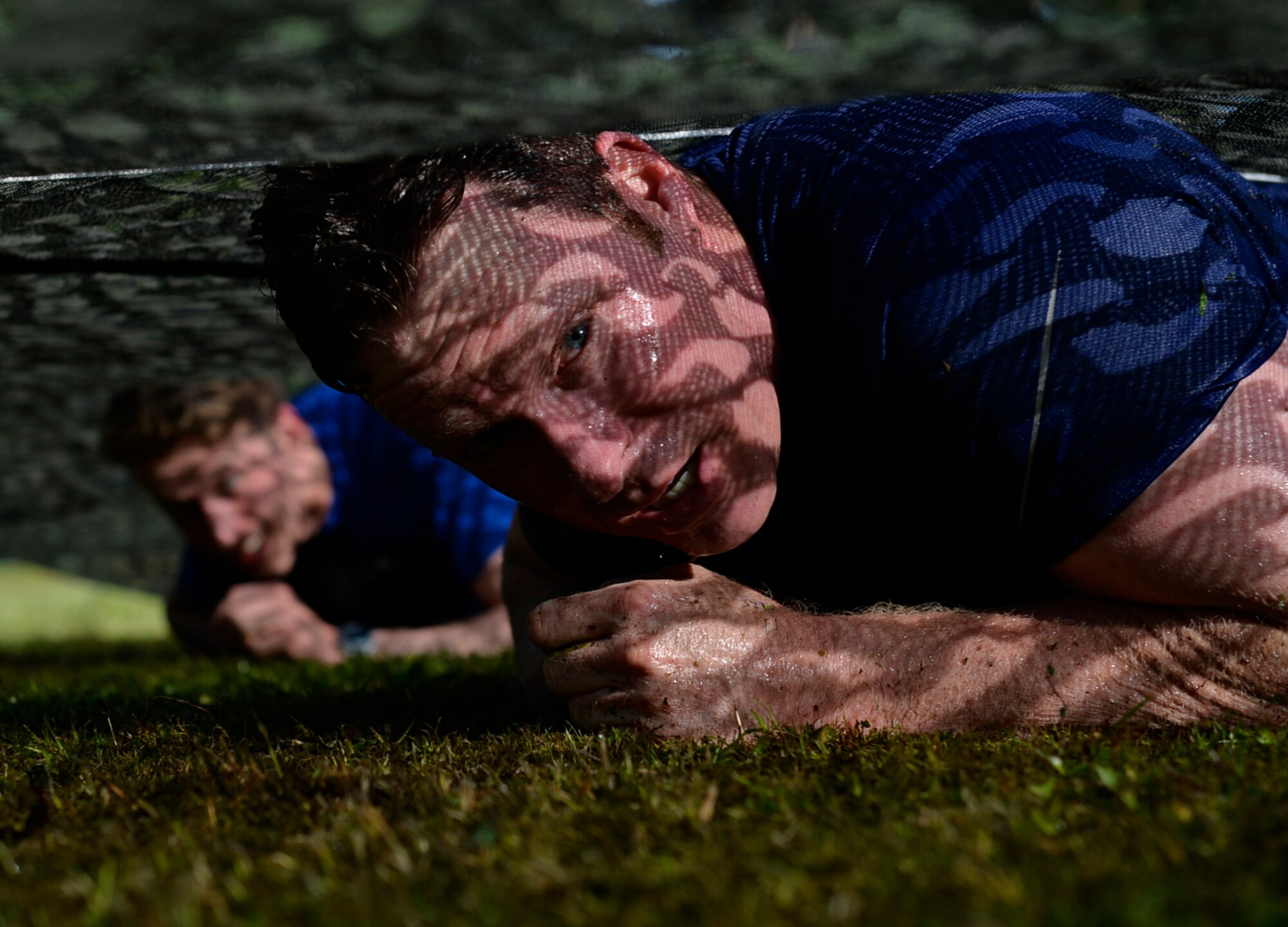 A Mudless Mudder participant low crawls, July 8, 2016 at Ramstein Air Base, Germany. The 86th Airlift Wing hosted the five-kilometer obstacle course for Resilience Day. (U.S. Air Force photo/ Senior Airman Nesha Humes)