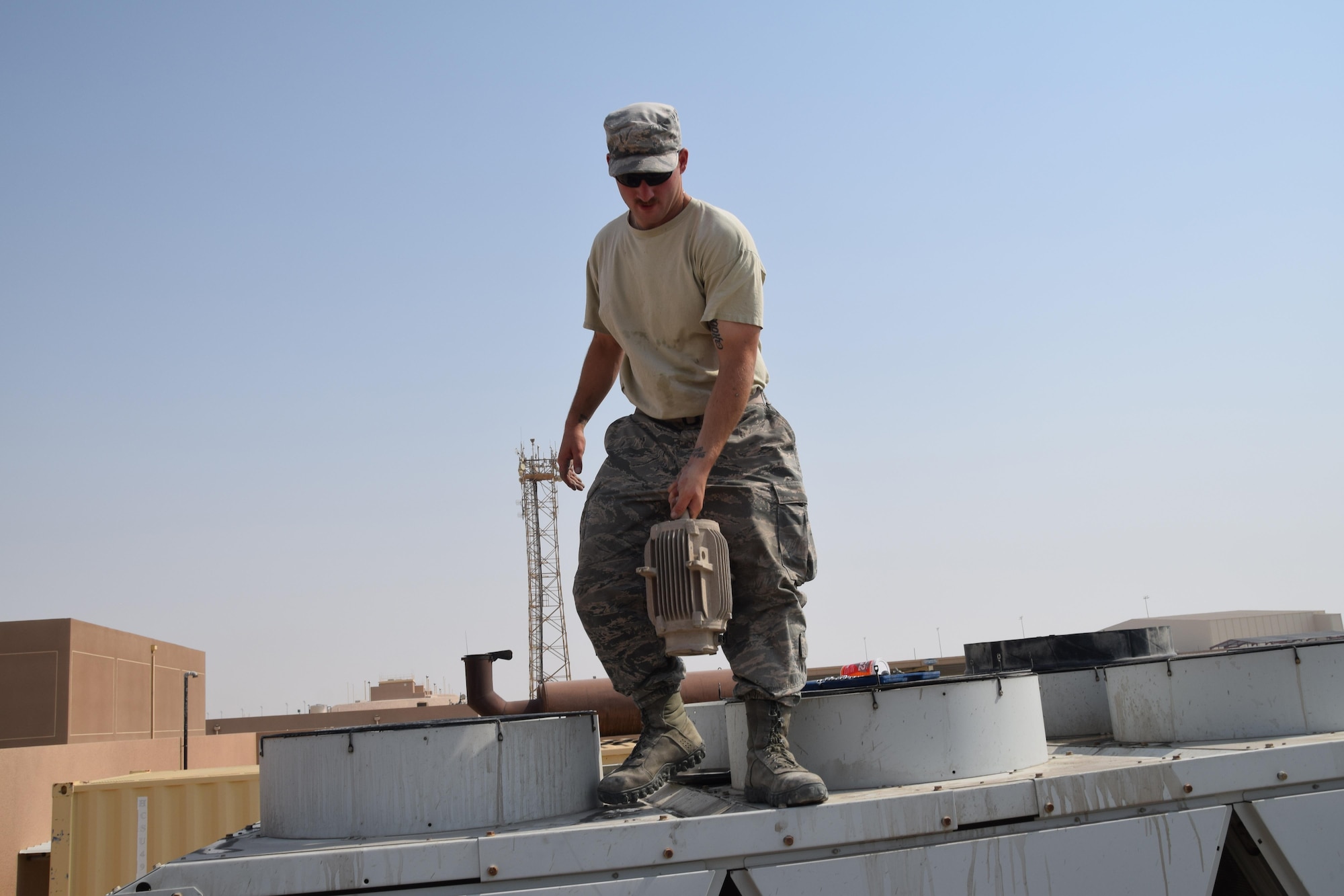 Senior Airman Shaun Berger, 379th Expeditionary Civil Engineering Squadron heating ventilation air conditioning and refrigeration journeyman, removes a motor from a chiller behind building 6671 June 27, 2016, at Al Udeid Air Base, Qatar. Despite a temperature of 117-degrees, Berger removed the motor, which had bad needed to be replaced due to bad windings. Climate control plays a large role in the comfort and efficiency of all coalition partners at work and in their quarters, in addition to keeping electronic equipment cool. (U.S. Air Force photo/Technical Sgt. Carlos J. Trevino/Released)