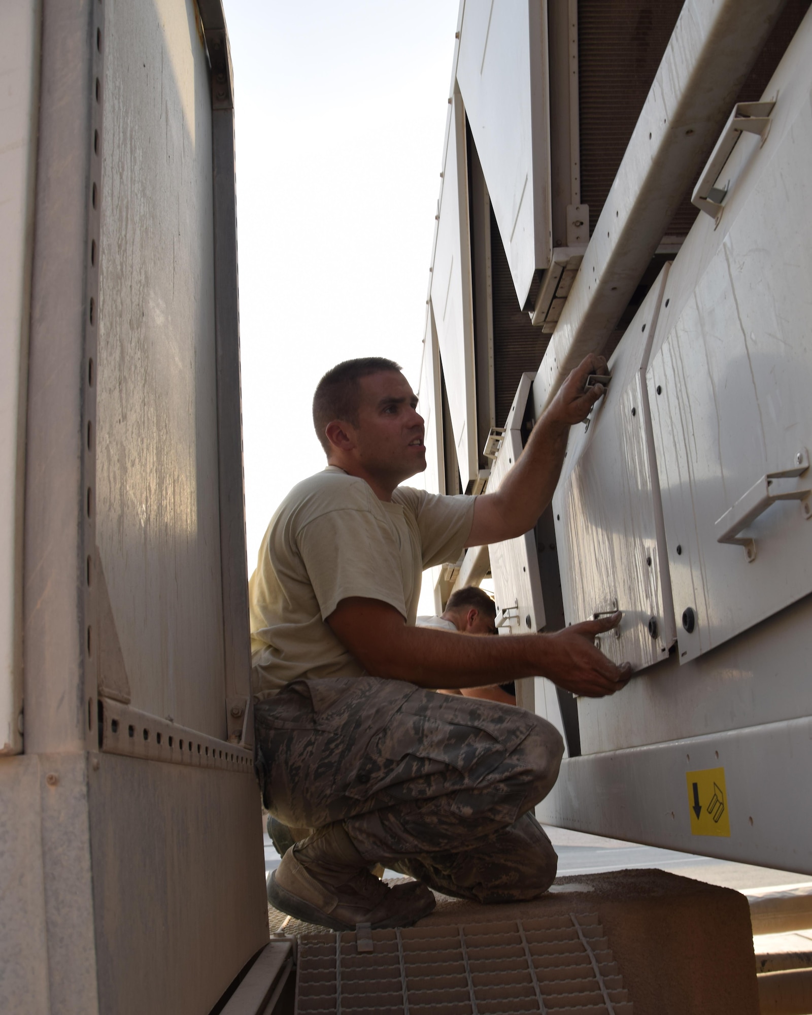 Staff Sgt. Erik Nelson, 379th Expeditionary Civil Engineering Squadron heating ventilation air conditioning and refrigeration journeyman removes a panel off a chiller behind building 6671 June 27, 2016, at Al Udeid Air Base, Qatar. Nelson and his hvac/r crew responded to repair the broken unit which supplies cool air to the wing operations center. Hvac crews respond to over 25 calls a day at Al Udeid to repair air conditioning and refrigeration units.   (U.S. Air Force photo/Technical Sgt. Carlos J. Treviño/Released) 

