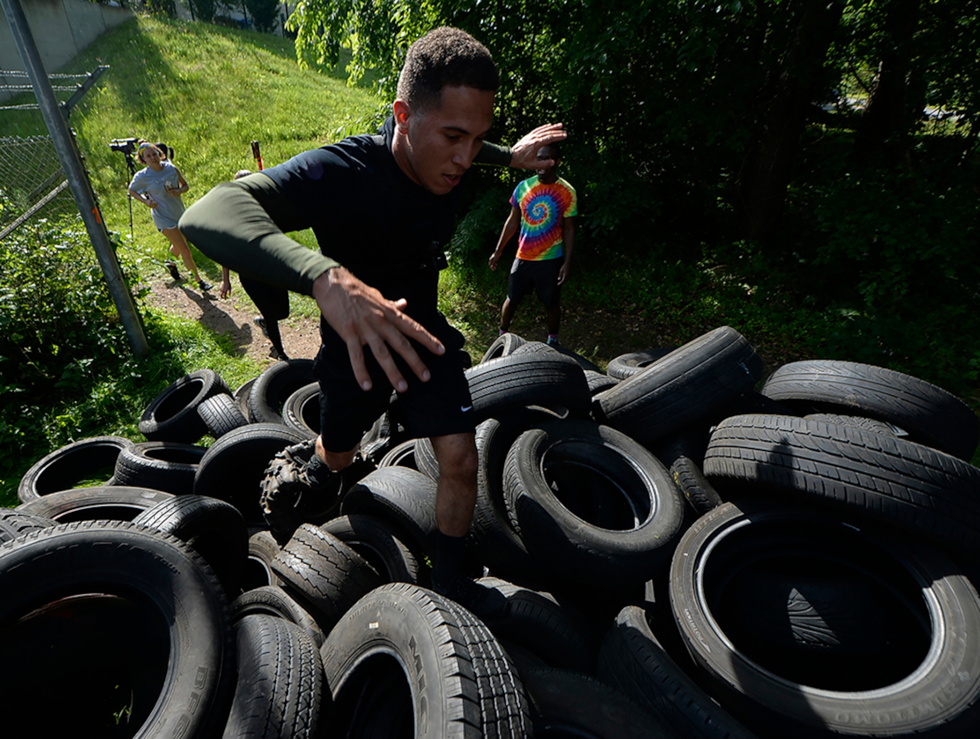Senior Airman Corinthian Maldonado, 86th Airlift Wing commander executive administrator, climbs a hill of tires at the Mudless Mudder on Ramstein Air Base, Germany, July 8, 2016. More than 550 participants competed in the five-kilometer obstacle course for the 86th AW Resiliency Day. (U.S. Air Force photo/ Senior Airman Nesha Humes)