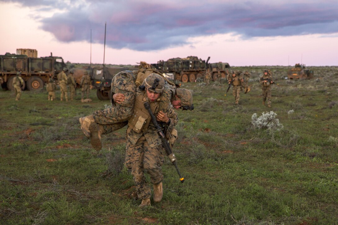 Marine Corps Sgt. Michael A. Polis carries a mock casualty after a simulated attack during Exercise Hamel at the Cultana Training Area in Australia, July 8, 2016. Polis is an intelligence specialist assigned to Headquarters and Service Company, 1st Battalion, 1st Marine Regiment, Marine Rotational Force Darwin. Marine Corps photo by Cpl. Mandaline Hatch 