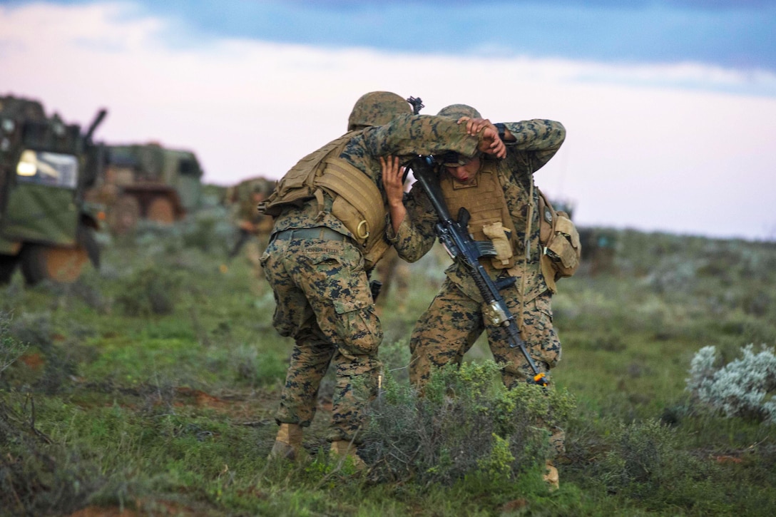 A Marine prepares to carry a mock casualty after a simulated attack during Exercise Hamel at the Cultana Training Area, Australia, July 8, 2016. Marine Corps photo by Lance Cpl. Osvaldo L. Ortega III