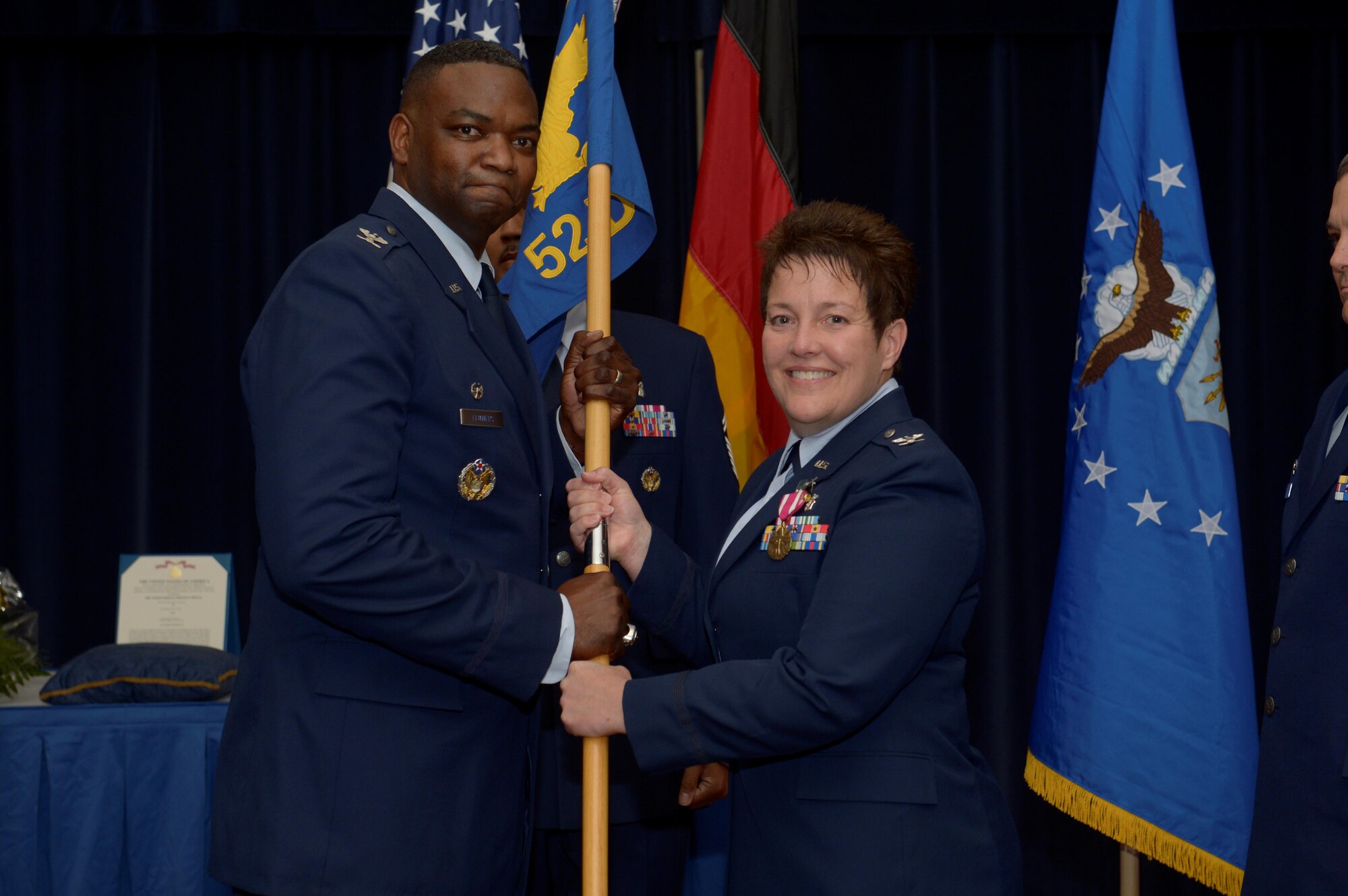 U.S. Air Force Col. Alfred Flowers, 52nd Medical Group commander, left, takes the ceremonial guidon from U.S. Air Force Col. Ann Blake, outgoing 52nd Dental Squadron commander, during the 52nd DS change of command ceremony on Spangdahlem Air Base, Germany, July 11, 2016. The guidon symbolized the authority Flowers placed on Blake, who then relinquished command over the 52nd DS
as the flag exchanged hands. (U.S. Air Force photo by Staff Sgt. Jonathan Snyder/Released)
