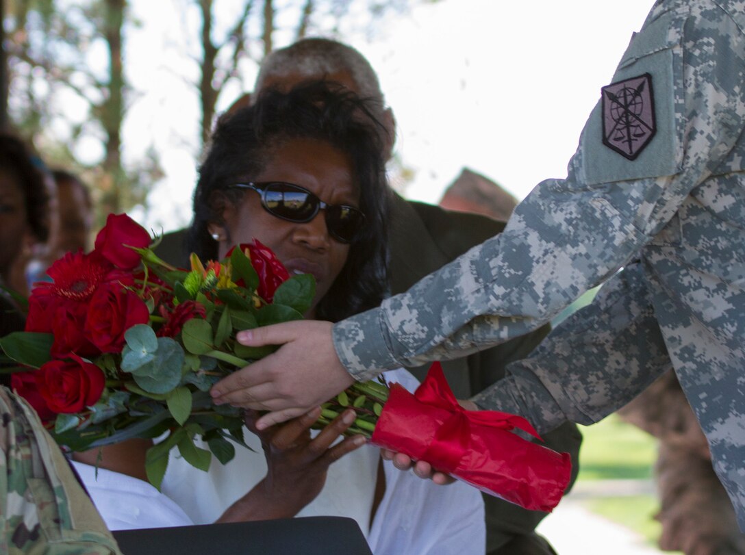 A Soldier from the 200th Military Police Command presents Robin Churn, Maj. Gen. Phillip M. Churn’s wife, a bouquet of red roses in appreciation of her attributions to the unit during the 200th MP Cmd’s relinquishment of command ceremony at the McGlachlin Parade Field, at Fort Meade, Md., July 10, 2016.  Lieutenant General Charles D. Luckey, chief of the Army Reserve and commanding general of the United States Army Reserve Command, was the reviewing official for the ceremony, in which Maj. Gen. Phillip M. Churn relinquished command to Brig. Gen. Marion Garcia. (U.S. Army photo by Spc. Stephanie Ramirez)