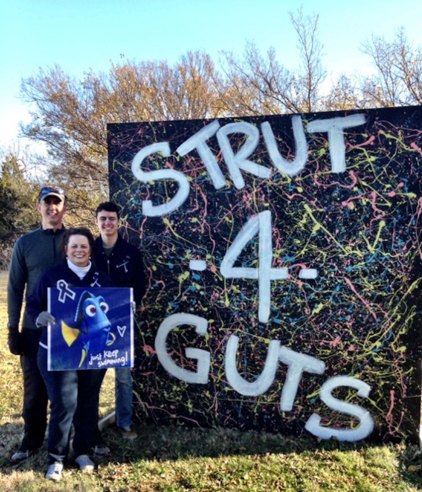 The family of Maj. Patrick Cain, 22nd Maintenance Squadron commander, hold up a sign at the Strut-4-Guts 5k race, Nov. 14, 2015, at Wichita, Kan. Cain, an avid long distance runner, was officially declared in remission June 7, 2016, after almost a year battle with colorectal cancer. 