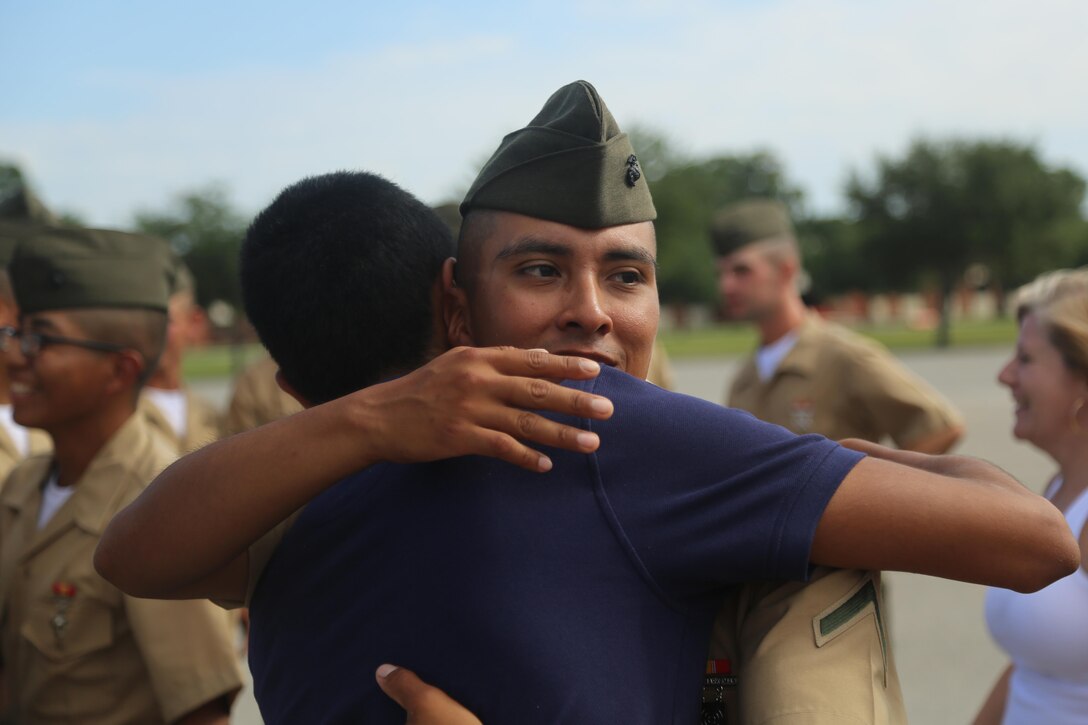 U.S. Marine Corps Pfc. Johnny Mendez with Lima Company, Recruit Training Regiment, Marine Corps Marine Recruit Depot Parris Island (MCRD PI), hugs Edwin Mendez, his brother, after a U.S. Marine Corps basic training graduation ceremony at Peatross Parade Deck, MCRD PI, S.C., July 8, 2016. Mendez graduated after 3 months of Marine Corps basic training. (U.S. Marine Corps photo by Lance Cpl. Colby Cooper/released)