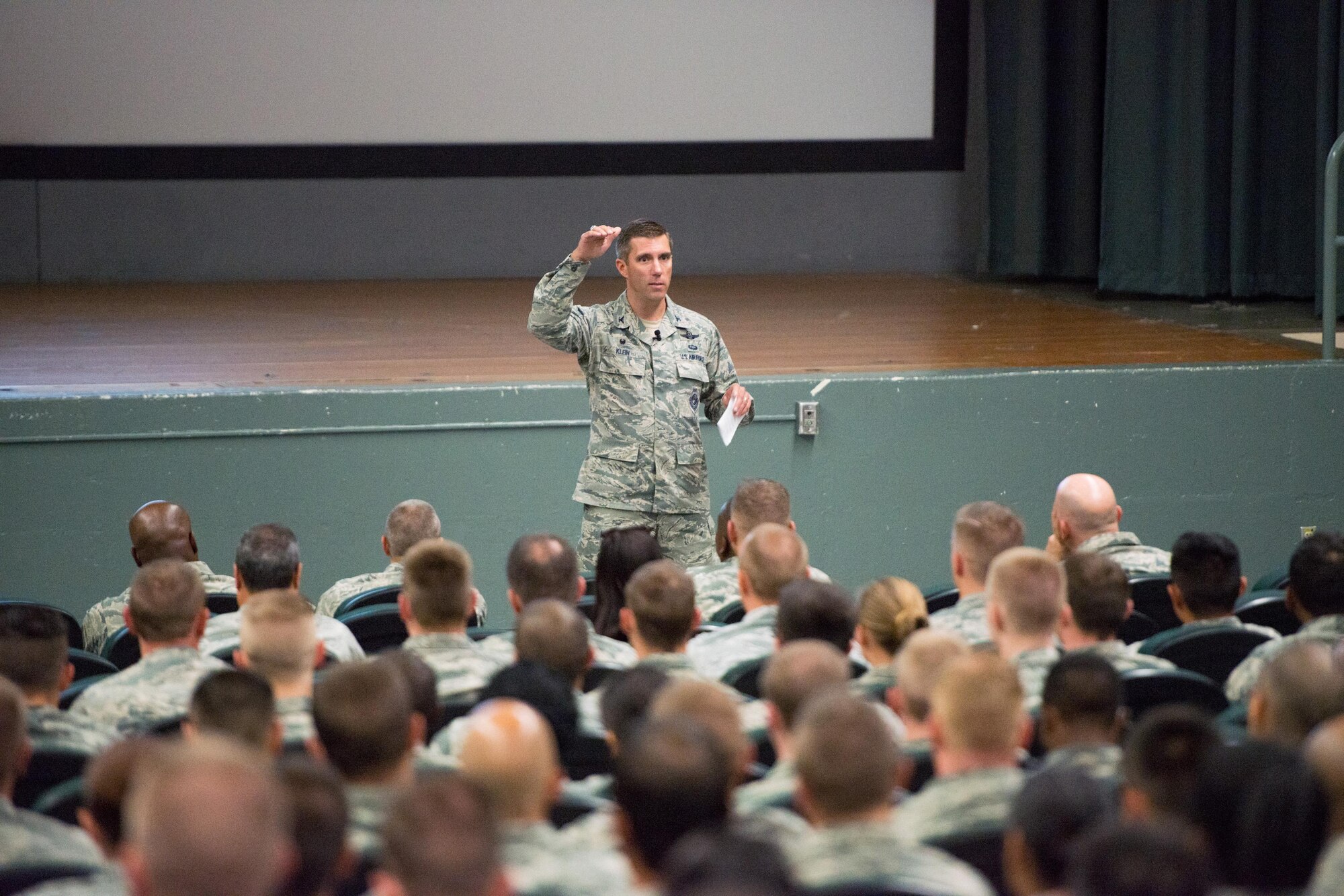 Col. John Klein,  60th Air Mobility Wing commander, at Travis Air Force Base, Calif., holds his first Travis all call at the base theater just two days after assuming command. Col. John Klein  has scheduled five all calls over a two day period and covered topics such as expectations, accountability, training and safety, June 30, 2016. (U.S. Air Force photo by Louis Briscese/Released) 