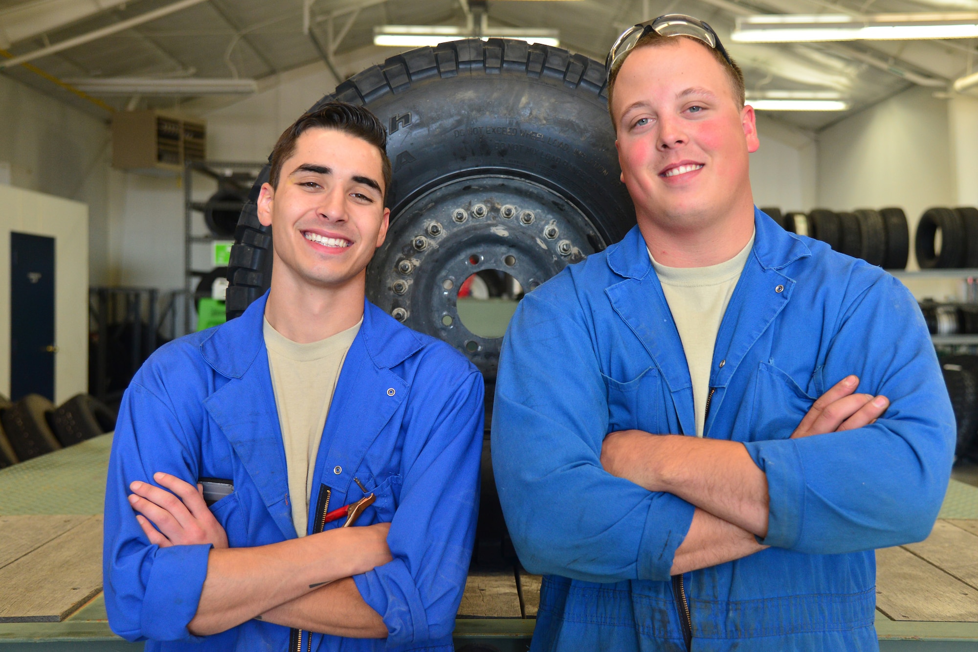 Senior Airmen Brennan Popp, left, and Hunter Dombek, 341st Logistics Readiness Squadron mission generating vehicular equipment maintenance technicians, pose for a photo in the tire shop July 7, 2016, at Malmstrom Air Force Base, Mont. Popp and Dombek are a two-man team responsible for replacing old, low-thread tires with ones that will assist Airmen in safely executing the base’s mission. (U.S. Air Force photo/Airman 1st Class Daniel Brosam)