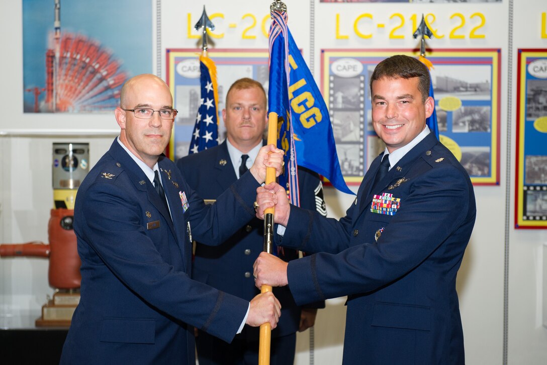 Col. Steven Lang, 45th Launch Group commander, presents Lt. Col. Waylon Mitchell, 5th Space Launch Squadron commander, with a guidon during a change of command ceremony July 7, 2016, at Cape Canaveral Air Force Station, Fla. Changes of command are a military tradition representing the transfer of responsibilities from the presiding official to the upcoming official. (U.S. Air Force photo/Benjamin Thacker/Released)