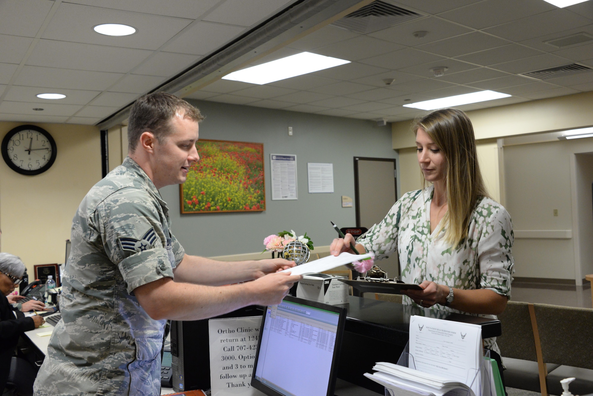 Senior Airman Scot Butler, 60th SGCS orthopedic technician, signs in a patient at the Orthopedic Clinic July 6 at Travis Air Force Base, California. 