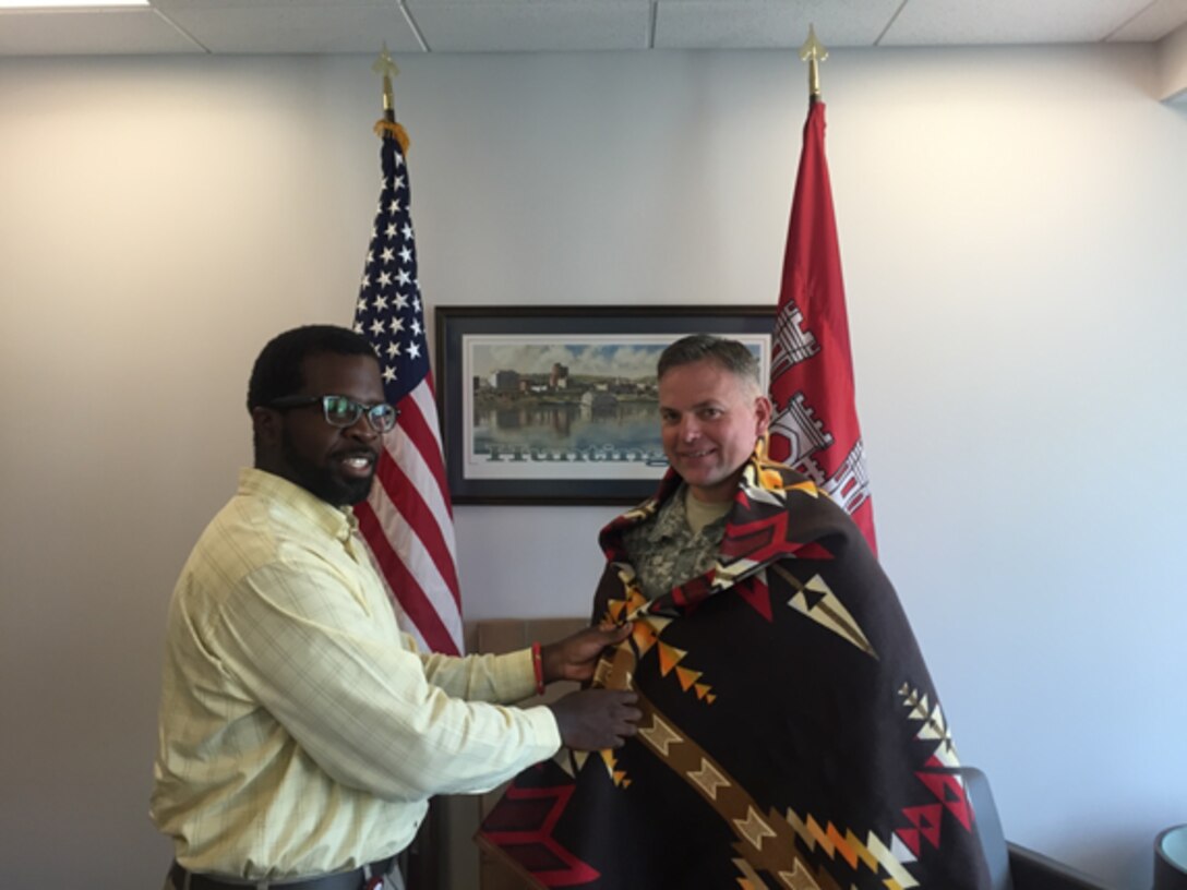 Rodney Parker, Huntington District Tribal Liaison presenting Col Philip Secrist with a Shawnee Blanket.
