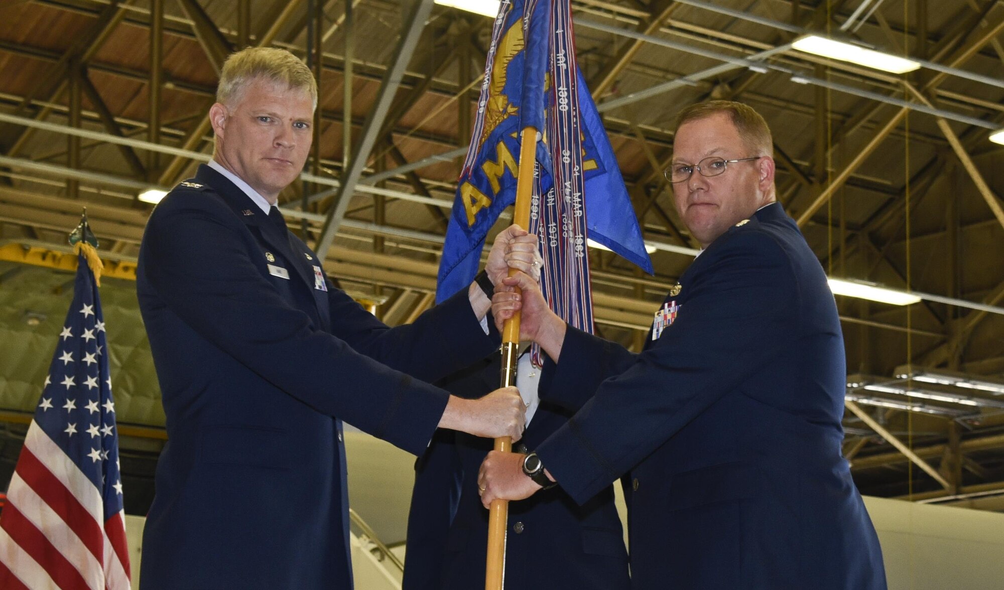 Col. Alan Hart, 92nd Maintenance Group commander, passes the 92nd Aircraft Maintenance Squadron guidon to Lt. Col. Leonard Shores, 92nd AMXS commander, during the change of command ceremony July, 7, 2016, at Fairchild Air Force Base, Wash. Shores was previously the 92nd Maintenance Squadron commander, the 92nd MXS main mission is to focus on the back shops while the 92nd AMXS works directly on the aircraft. (U.S. Air Force photo/Airman 1st Class Taylor Shelton)