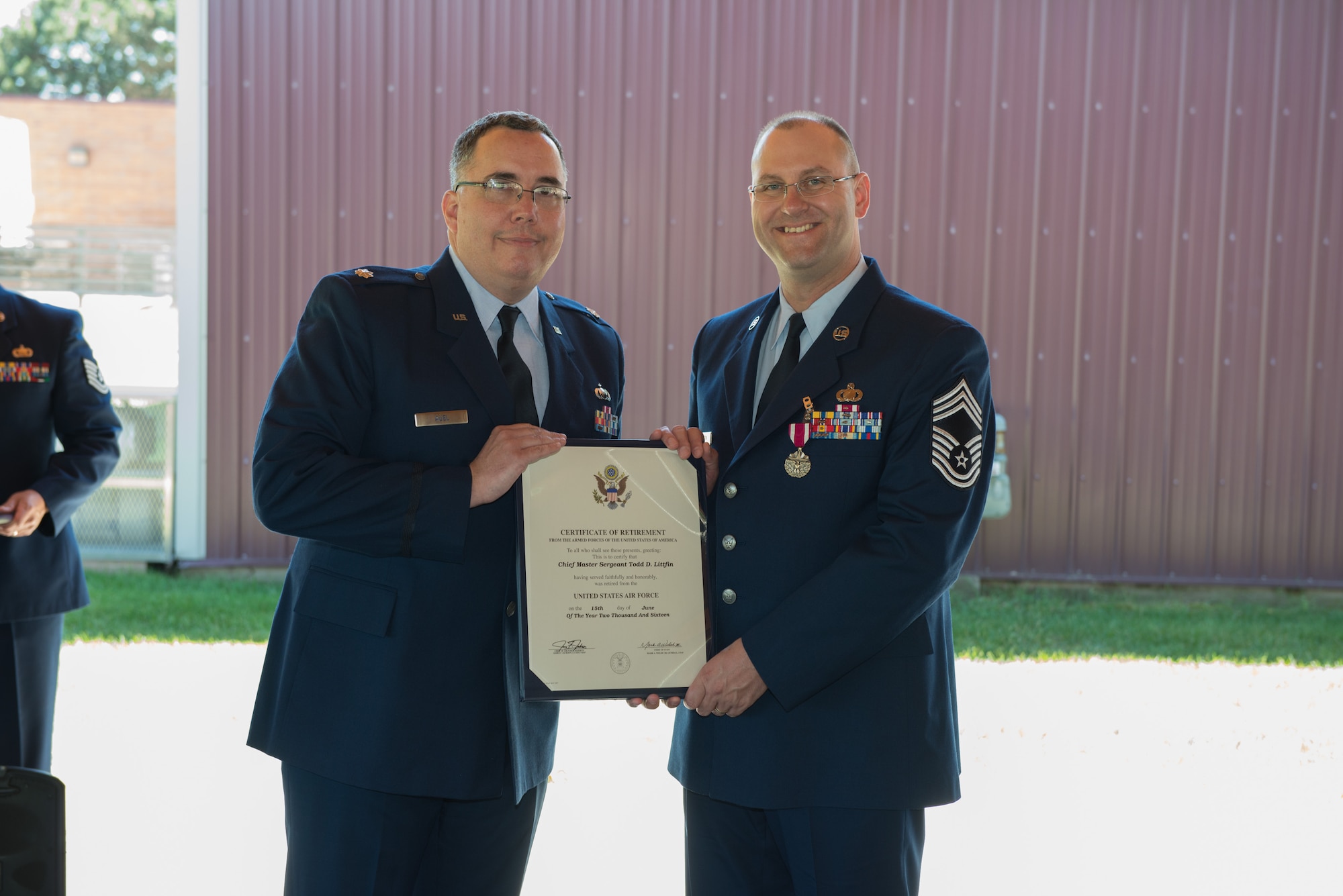 Lt. Col. Mike Auel (left) presents Chief Master Sgt. Todd Littfin with his retirement certificate July 9.  