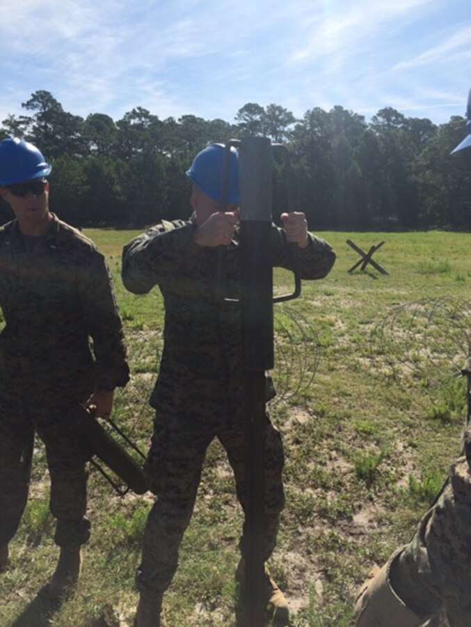 On June 13, 2016 Second Lieutenants Thomas Cofer (left) and Nicholas Downey (right), Marines attached to Combat Engineer Officer course 5-16 (CEO 5-16); drive engineer stakes into the ground to create a wire obstacle. Combat Engineer Officer students receive demonstrations and practical application training of a number of obstacles employed by the Marine Corps.
