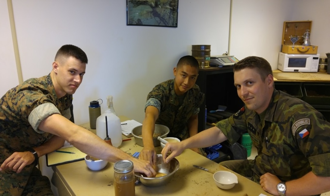 During a soil classification practical application on July 7, 2016 Second Lieutenants Jacob Cybulski (left), Garret Cheung (middle), and Czech Republic First Lieutenant Jakub Kominek (right); students attached to Combat Engineer Officer course 7-16 (CEO 7-16); prepare to perform a Grit Field Test. A Grit Field Test is a test where combat engineers place a pinch of soil between their teeth and bite to classify the soil. Soil classification is used to determine the potential behavior of soil under traffic or foundation loads.
