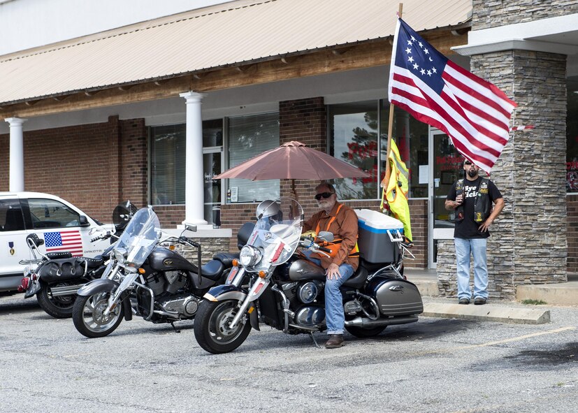A member of the Combat Veterans Motorcycle Association’s 25-5 chapter sits in the shade prior to a memorial ride in honor of U.S. Air Force Tech. Sgt. Lee “Blaster” Fulp, July 9, 2016, in Valdosta, Ga. Attached to his bike is a replica of one of America’s first flags, originally sown by Betsy Ross with 13 stars representing the original 13 colonies. (U.S. Air Force photo by Airman 1st Class Janiqua P. Robinson/Released)