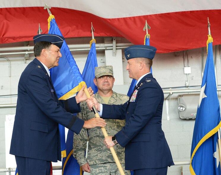 Lt. Gen. Brad Heithold, commander of Air Force Special Operations Command, passes the Air Force Special Operations Air Warfare Center guidon to Col. Nathan Green, AFSOAWC commander, during a change of command ceremony at Hurlburt Field, Fla., July 11, 2016. (U.S. Air Force photo/Staff Sgt. Melanie Holochwost)