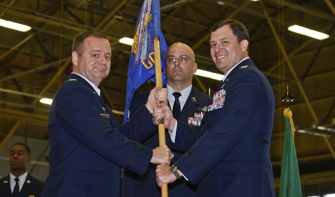 Col. Brian McDaniel, 92nd Air refueling Wing Commander, passes the 92nd Operations Group guidon to Col. Barry Cargle, 92nd OG commander, during the change of command ceremony July, 8, 2016, at Fairchild Air Force Base, Wash. Cargle was previously the Chief of Programs Division, Directorate of Strategic Plans, Requirements and Programs, Headquarters Air Mobility Command, Scott Air Force Base, Illinois. (U.S. Air Force photo/Airman 1st Class Taylor Shelton)