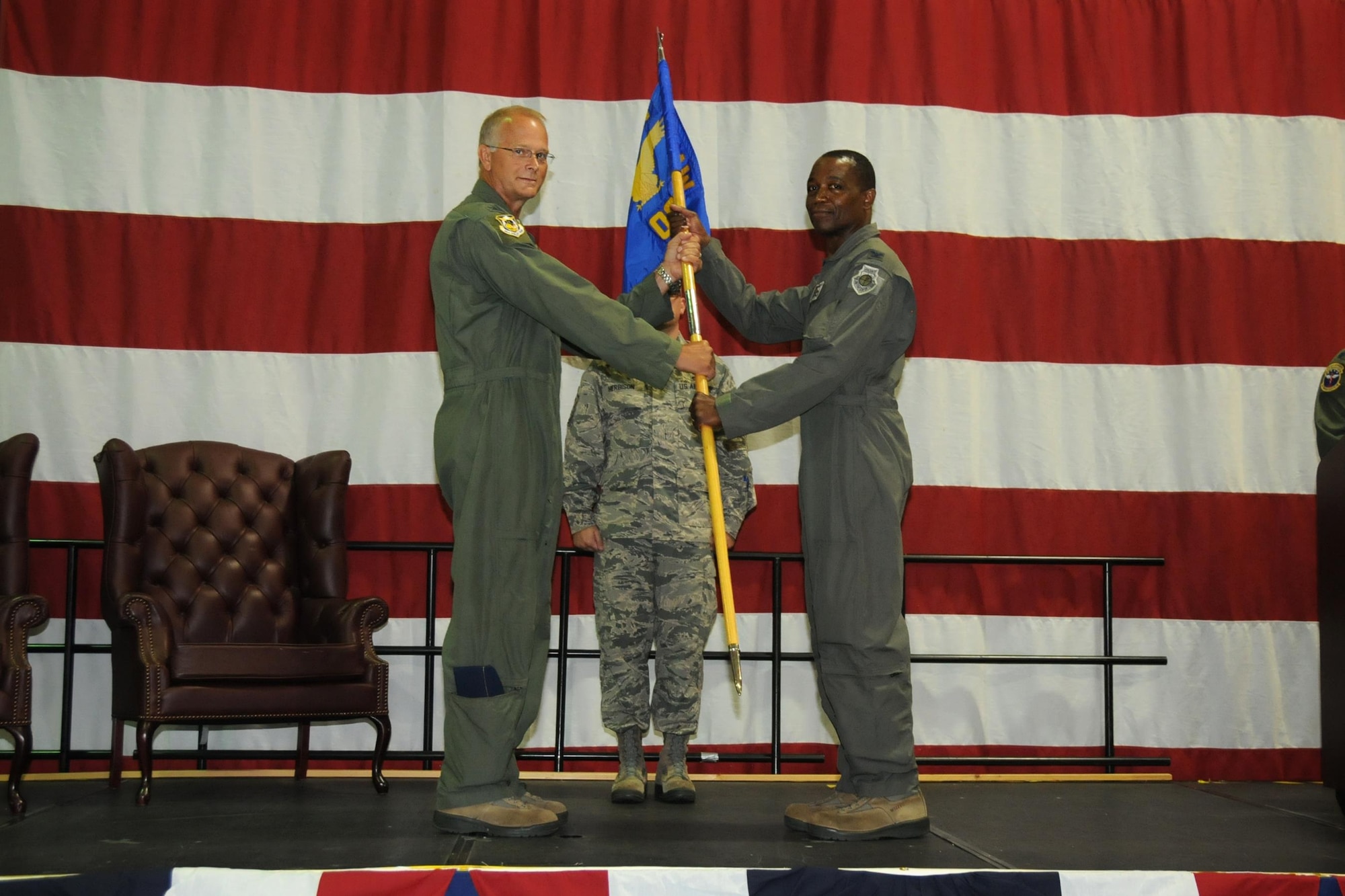 Col. Steven Parker, 94th Airlift Wing commander, passes the guidon to Col. Patrick Campbell during a change of command ceremony at Dobbins Air Reserve Base, Georgia, on July 10, 2016. Campbell formally assumed command of the 94th Operations Group during the event. (U.S. Air Force photo by Staff Sgt. Alan Abernethy)