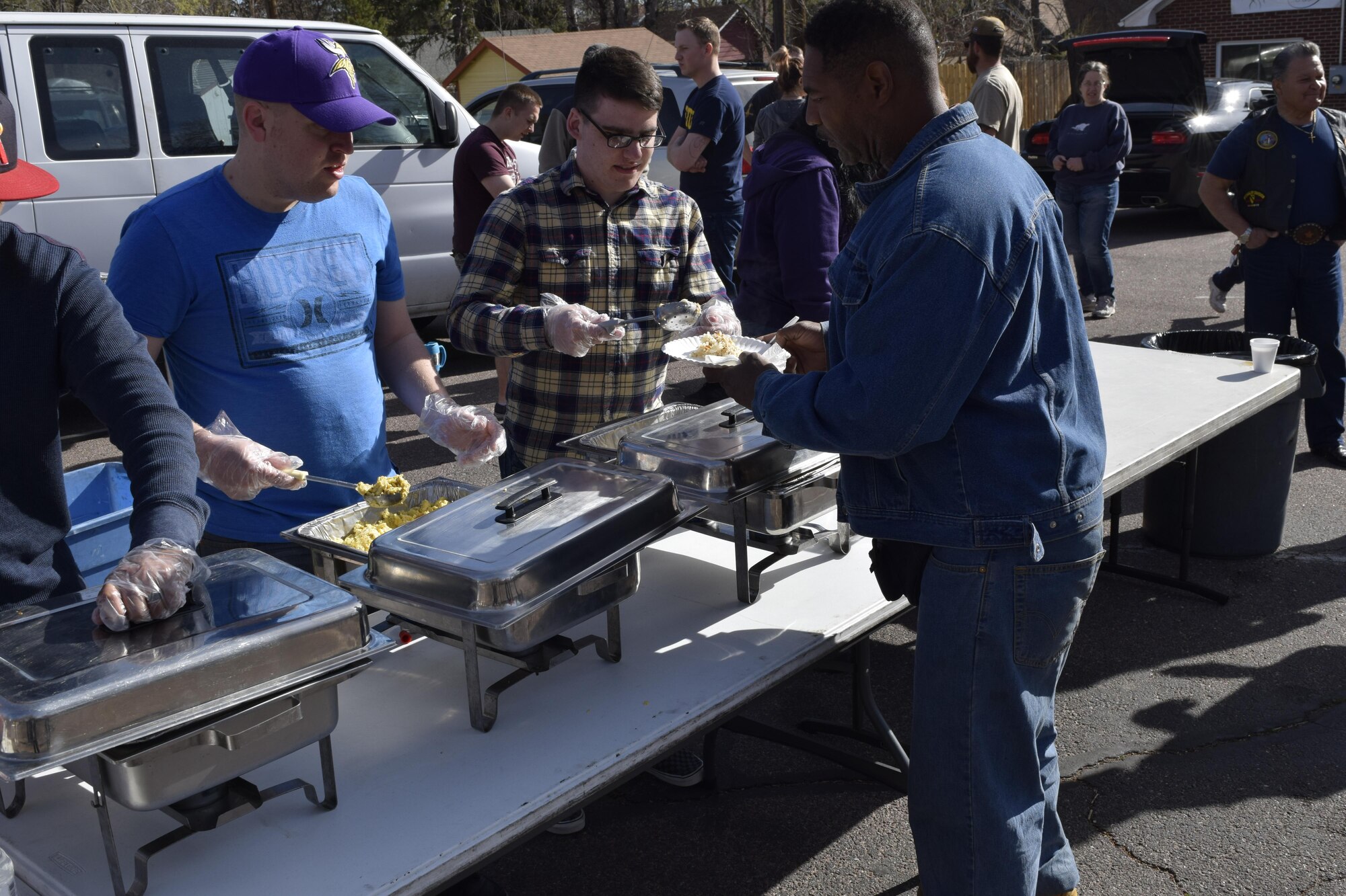 PETERSON AIR FORCE BASE, Colo. – Senior Airman Andrew Revier, left, and   Airman 1st Class Davis Walker, serve food to homeless and hungry people during a More Than a Meal serving. Junior enlisted members of Team Pete volunteer in the community with several organizations, often through the Junior Enlisted Association. (Courtesy photo)