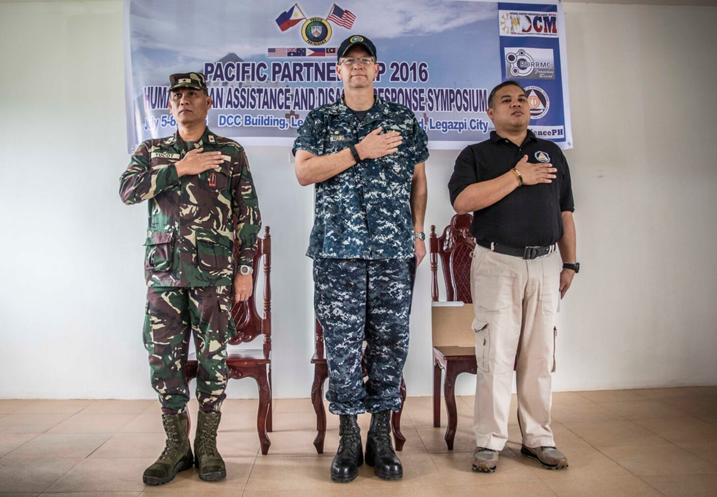Philippine Air Force Brig. Gen. Claudio L. Yucot (left), U.S. Navy Capt. Tom Williams, mission commander, Pacific Partnership 2016 (center), and Director Bernardo R. Alejandro IV, regional director, Office of Civil Defense 5, render honors during the Philippine national anthem at the start of a Humanitarian Assistance Disaster Relief workshop in support of Pacific Partnership 2016. During the three-day workshop, co-hosted by the Armed Forces of the Philippines and Pacific Partnership 2016, Filipino civilians and military service members coordinated a tabletop exercise to simulate multilateral disaster response among partners during a crisis. Pacific Partnership is visiting the Philippines for the seventh time since its first visit in 2006. Partner nations are working side-by-side with local military and non-government organizations to conduct cooperative health engagements, community relation events and subject matter expert exchanges to better prepare for a natural disaster or crisis. 