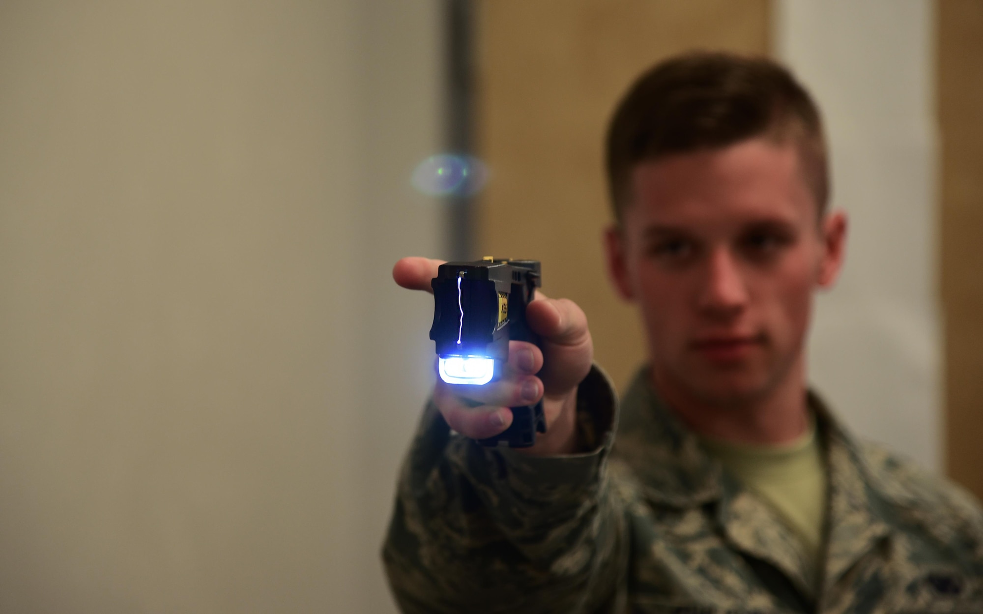 PETERSON AIR FORCE BASE, Colo. – Senior Airman Cameron Chilcote, 21st Security Forces Squadron unit scheduler, demonstrates the ‘dry stun’ aspect of a X26 Taser during a training course on Peterson Air Force Base, Colo., July 7, 2016. After the probes have been fired the X26 Taser is still capable of administering 50,000 volts of electricity through direct application which is referred to as a dry stun. (U.S. Air Force photo by Staff Sgt. Amber Grimm)