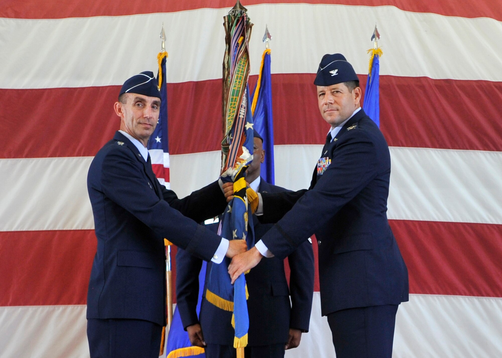 U.S. Air Force Maj. Gen. Scott J. Zobrist, commander of 9th Air Force Air Combat Command (left), passes the 325th Fighter Wing guidon to Tyndall’s new commander, Col. Michael Hernandez July 11. Hernandez was previously the vice commander of the 482nd Fighter Wing at Homestead Air Reserve Base, Fla. (U.S. Air Force photo by Senior Airman Sergio A. Gamboa/Released)