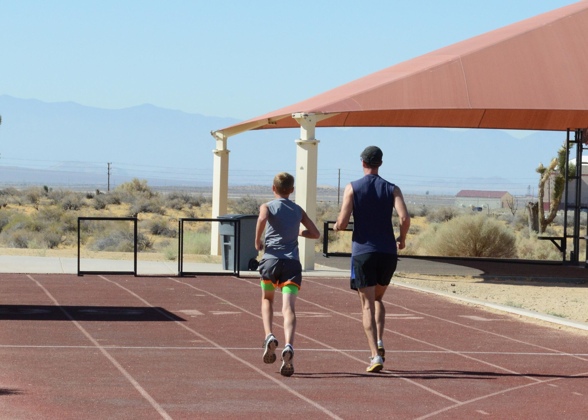 Eleven-year-old Zack Gilbertson and volunteer coach, Senior Airman Benjamin Kinley, 412th Maintenance Squadron, head off the track to a running trail July 7. Zack is preparing to compete in the 3000 meter run at the 50th Annual USA Track and Field National Junior Olympics Championships July 30. (U.S. Air Force photo Kenji Thuloweit)

