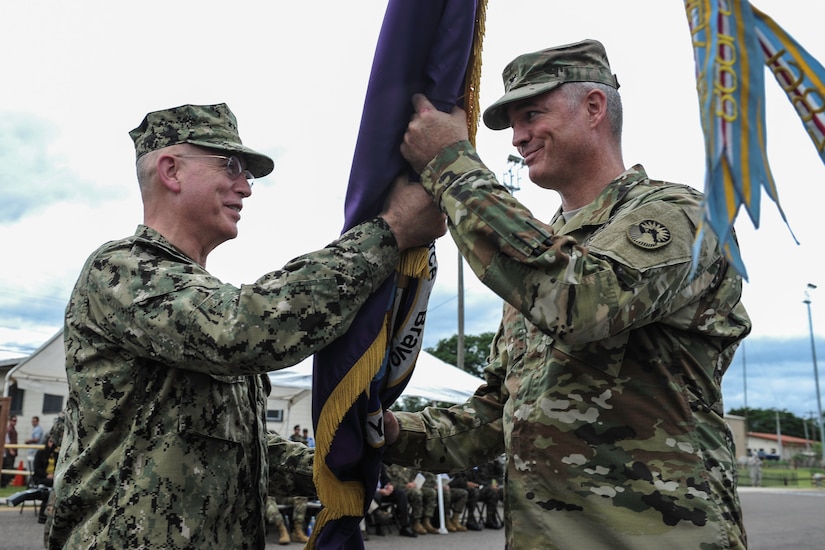 U.S. Navy Adm. Kurt Tidd, commander of U.S. Southern Command, passes the Joint Task Force-Bravo guidon to U.S. Army Col. Brian Hughes, signifying Hughes’ assumption of command of JTF-Bravo, during the JTF-Bravo change of command ceremony at Soto Cano Air Base, Honduras, July 7, 2016. Hughes served as the Army Special Operations Aviation Command operations officer and interim chief of staff at Fort Bragg, N.C., followed by a National Security Fellowship at the University of North Carolina, prior to assuming command of JTF-Bravo. (U.S. Air Force photo by Staff Sgt. Siuta B. Ika)