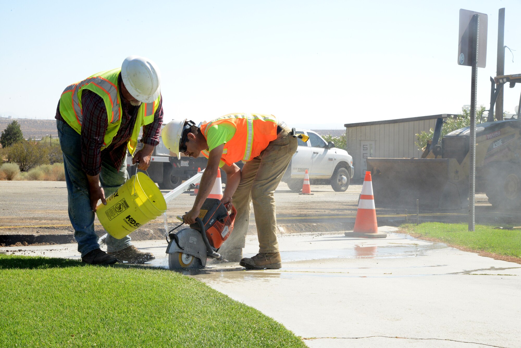 Trent Duncan (left) and Oscar Soto of Duran Construction cut a piece of concrete from the walkway at Muroc Lake Golf Course. The contractors began work Tuesday to repair the parking lot for the golf course, the parking lot for Building 5601 (Lodging), and Crossfield Road.  The repairs are expected to take approximately three weeks.  Access and parking for the Golf Course will remain open although will be limited to half of the parking lot.  Parking lot for Building 5601 will be closed, alternate parking will be provided behind the building. (U.S. Air Force photo by Christopher Ball) 