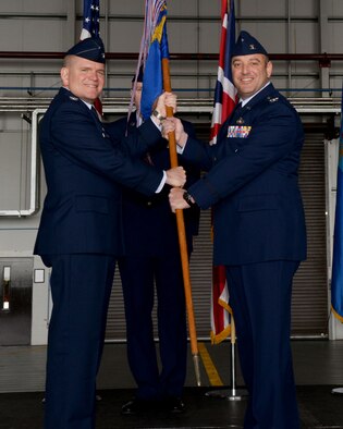 U.S. Air Force Col. Thomas Torkelson, left, 100th Air Refueling Wing commander, passes the guidon to U.S. Air Force Col. Robert Hoskins, right, new 100th Mission Support Group commander, June 29, 2016, during a change of command ceremony on RAF Mildenhall, England. The ceremony is a time-honored tradition in which one officer relinquishes command and passes it to another. (U.S. Air Force photo by Airman 1st Class Tenley Long/Released)