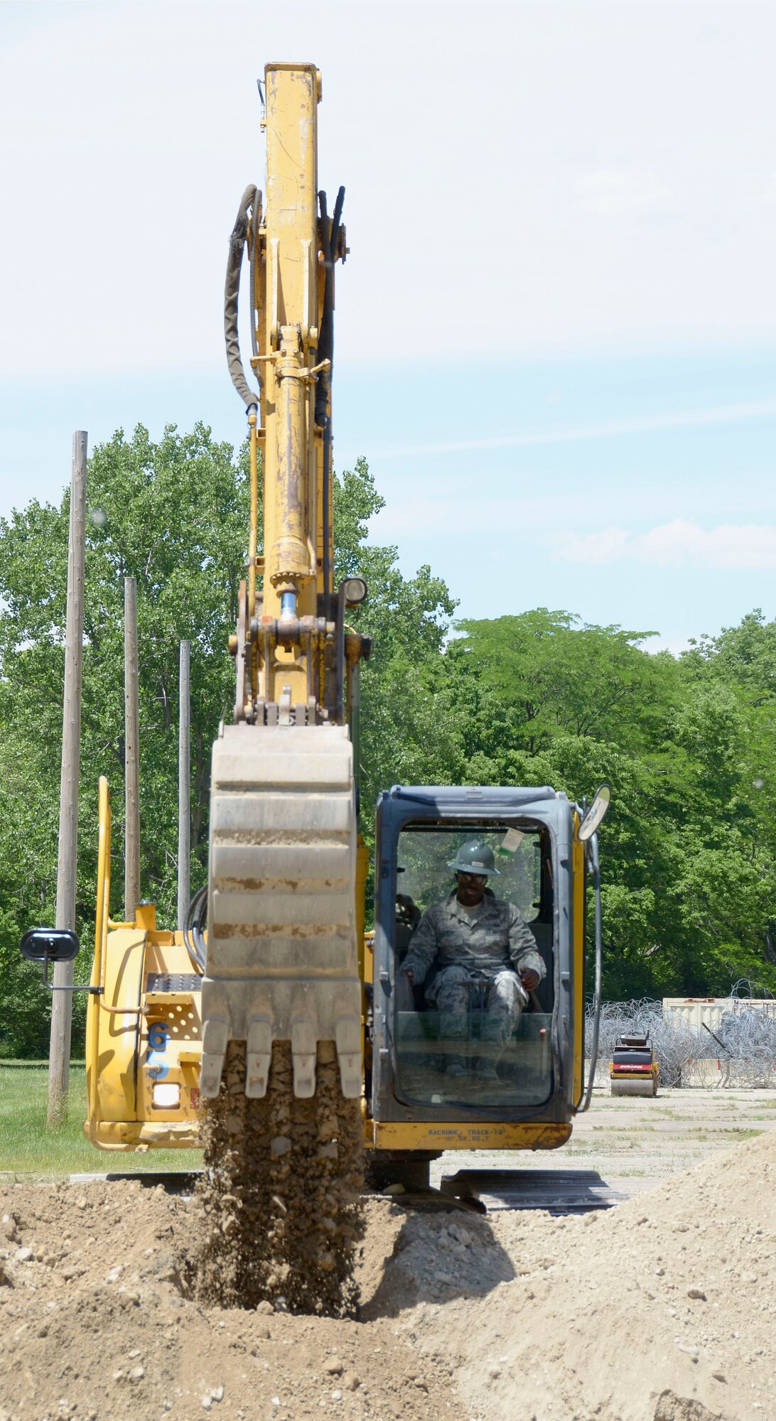 Senior Airmen Diondre Jenkins, an electrical systems civil engineer from 445 CES, operates an excavator. Airmen operating the excavator practiced basic digging and transportation procedures, June 3, 2016, at the Wright-Patterson Air Force Base Warfighter Training Center. The entire CES completed bivouac (temporary camp without tents or cover) training June 3-4, 2016 as part of the wing’s unit effectiveness inspection. (U.S. Air Force photo/Senior Airmen Joel A. McCullough)