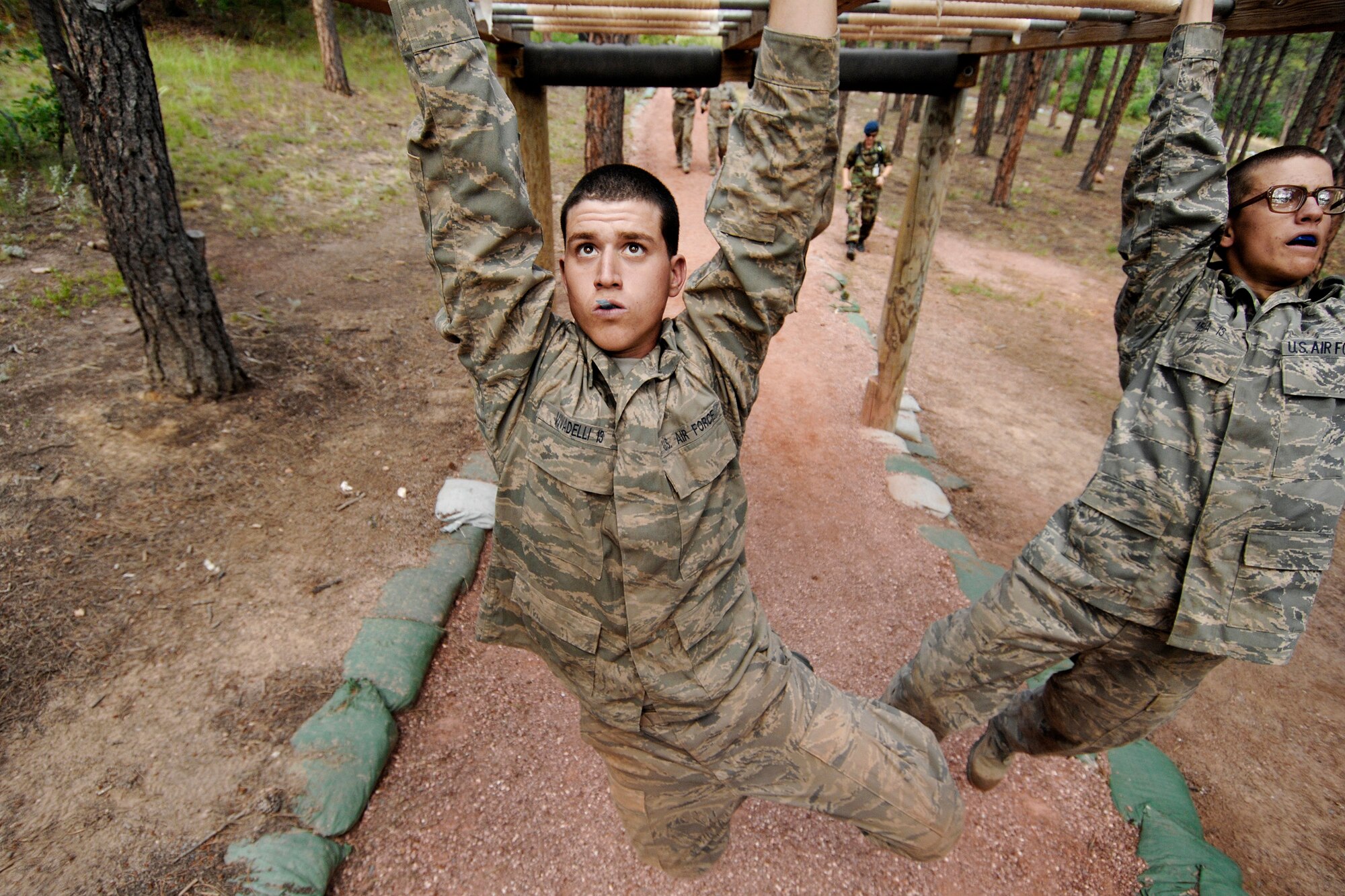 Basic cadets race through the monkey bars on the Jacks Valley Assault Course during Basic Cadet Training at the U.S. Air Force Academy. Basic cadets earn their status as cadets fourth class on Acceptance Day. (U.S. Air Force Photo/Dennis Rogers)