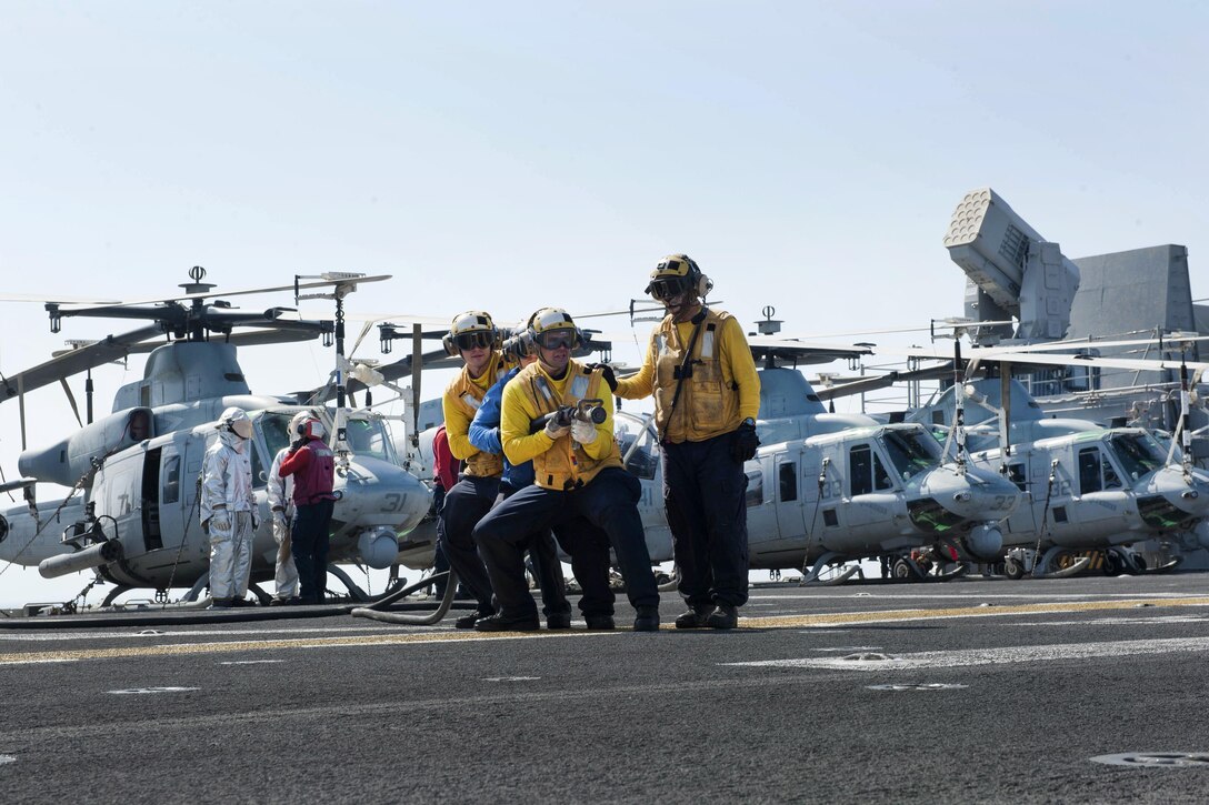 Sailors participate in a fire drill on the flight deck of amphibious assault ship USS Boxer in the Arabian Gulf, July 8, 2016. Navy photo by Seaman Eric Burgett