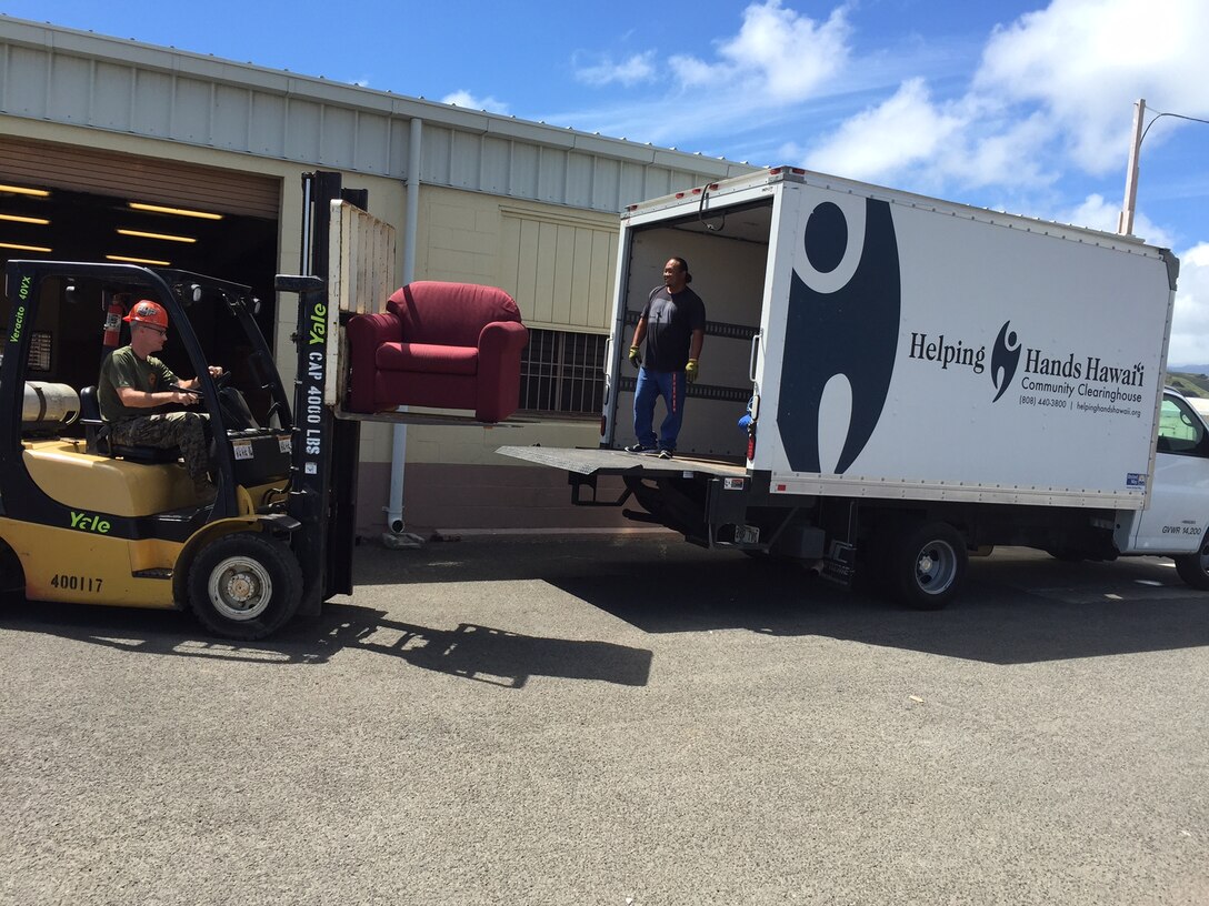 A Marine loads one of 407 pieces of old barracks furniture that the Defense Logistics Agency helped Marine Corps Base Hawaii donate to a local charity instead of disposing of the unneeded items in a landfill. 