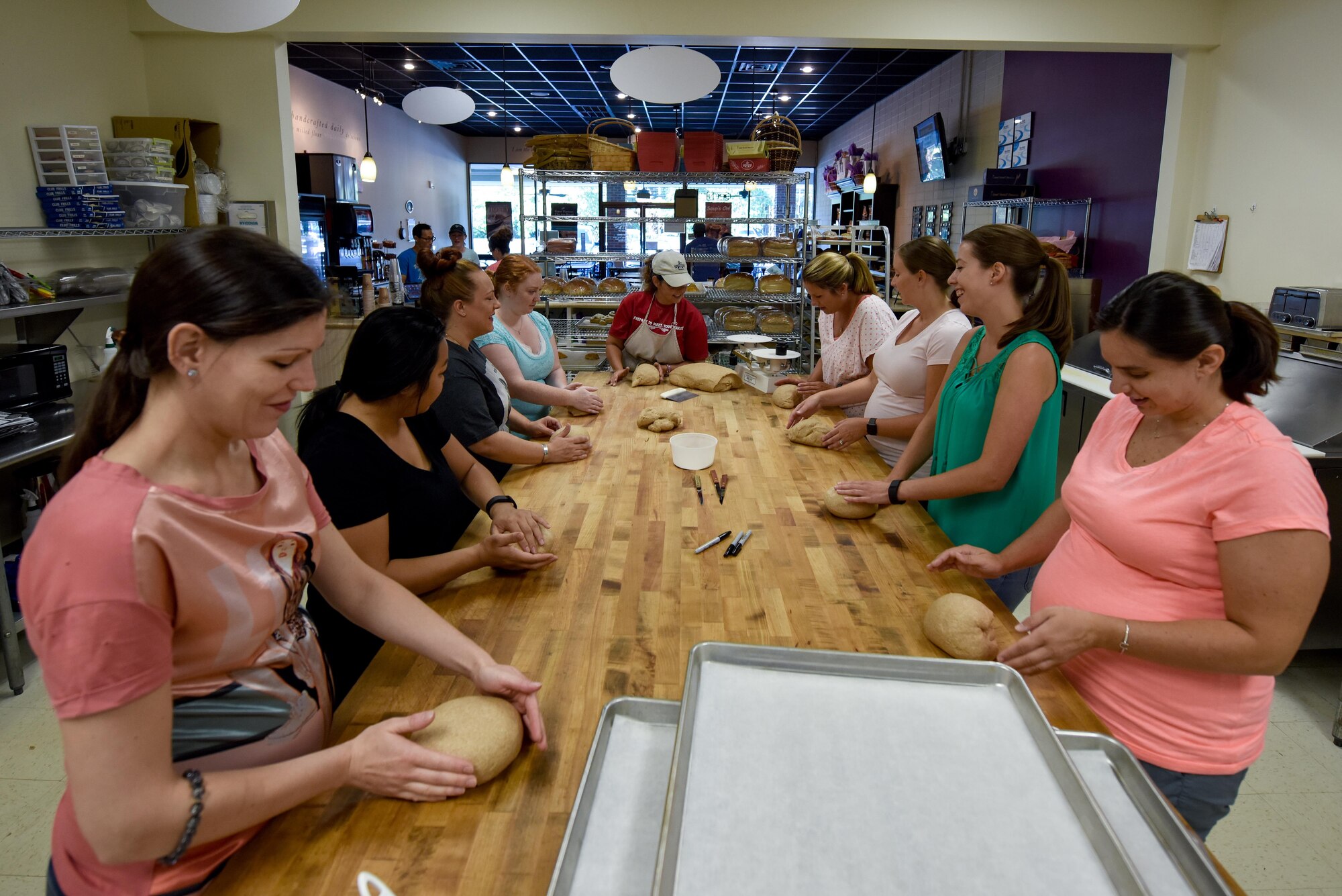 Michele Jones, local bread company co-owner, shows spouses from Team Seymour how to prepare bread, July 9, 2016, in Goldsboro, North Carolina. During an instructional workshop as part of the Hearts Apart program, spouses learned about the entire bread-making process. (U.S. Air Force photo by Airman Shawna L. Keyes)