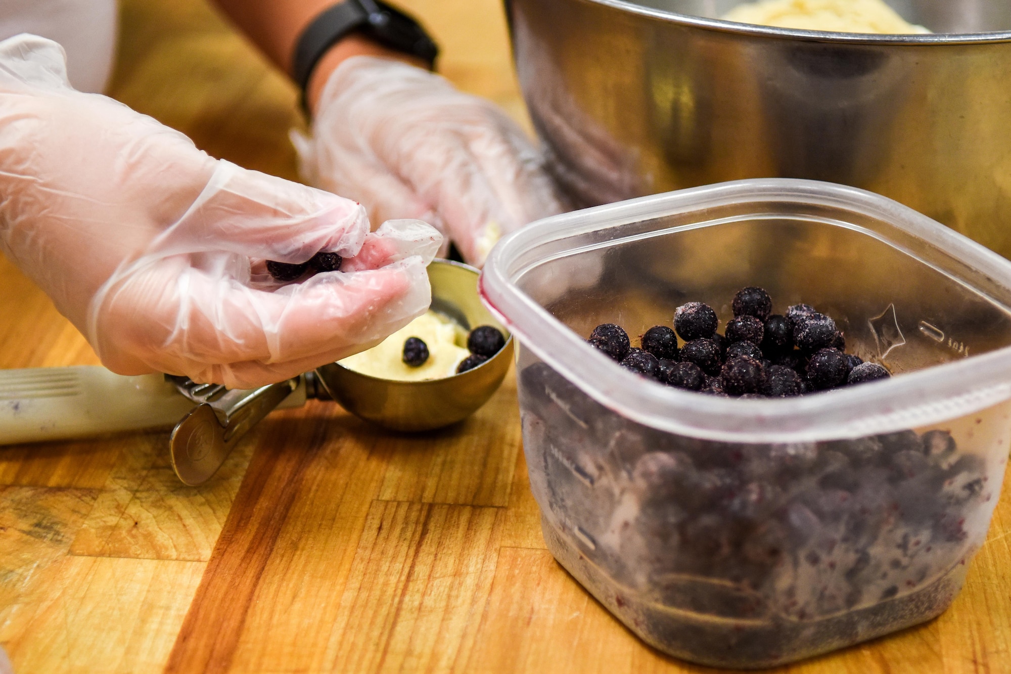 Samantha Smith, wife of Staff Sgt. Travis Smith, 4th Civil Engineer Squadron heavy equipment and pavement operator, makes blueberry scones at a local bread company, July 9, 2016, in Goldsboro, North Carolina. The Hearts Apart program collaborated with the company to host an instructional workshop on baking bread and other bakery products. (U.S. Air Force photo by Airman Shawna L. Keyes)