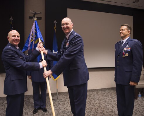 From left: Brig. Gen. Carl Schaefer, 412th Test Wing commander, hands Col. George Tromba the 412th Mission Support Group guidon as outgoing commander Col. Eric Leshinsky looks on. (U.S. Air Force photo by Joseph Gocong) 