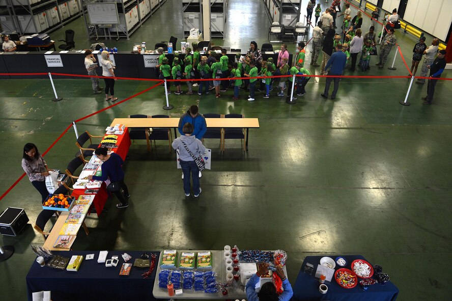 Children process through a simulated deployment line during a Kids Understanding Deployment Operations event July 9, 2016, on McChord Field, Wash. KUDOs included a simulated deployment line; face painting; C-17 Globemaster III static display; and entertaining demonstrations from the JBLM fire department, 22nd Special Tactics Squadron and JBLM explosive ordnance disposal section. (U.S. Air Force photo/Senior Airman Divine Cox)