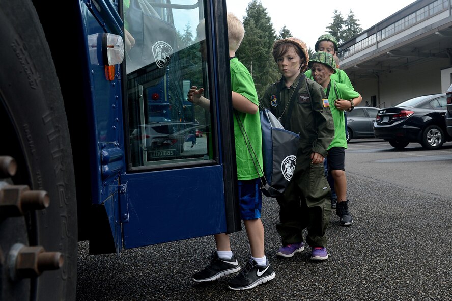 Children load onto a bus to depart to their simulated deployed location during a Kids Understanding Deployment Operations event July 9, 2016, on McChord Field, Wash. After the children received all of their deployment gear, buses drove them to Hangar 9 where they were greeted by various McChord leadership and were briefed on what to expect. (U.S. Air Force photo/Senior Airman Divine Cox)