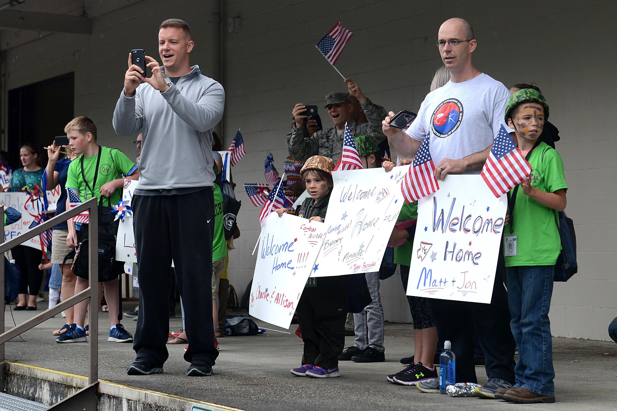 Joint Base Lewis McChord parents celebrate the home coming of their children during a Kids Understanding Deployment Operations event July 9, 2016, on McChord Field, Wash. After deploying to Camp Kudo at hangar 9, the children arrived back to their home station where family and friends were waiting to congratulate them. (U.S. Air Force photo/Senior Airman Divine Cox)