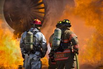 5th Civil Engineer Squadron firefighters hose down a fire during a training exercise at Minot Air Force Base, N.D., July 8, 2016. The fire department trains regularly to maintain readiness. (U.S. Air Force photo/Airman 1st Class Christian Sullivan)