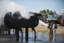 5th Civil Engineer Squadron firefighters hose down a fire during a training exercise at Minot Air Force Base, N.D., July 8, 2016. The fire protection flight’s goal is to protect MAFB’s people, property and the environment from fires and disasters by providing fire prevention, firefighting, rescue and hazardous material response. (U.S. Air Force photo/Airman 1st Class Christian Sullivan)