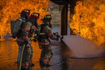 5th Civil Engineer Squadron firefighters hose down a fire during a training exercise at Minot Air Force Base, N.D., July 8, 2016. The fire department trains regularly to maintain readiness. (U.S. Air Force photo/Airman 1st Class Christian Sullivan)