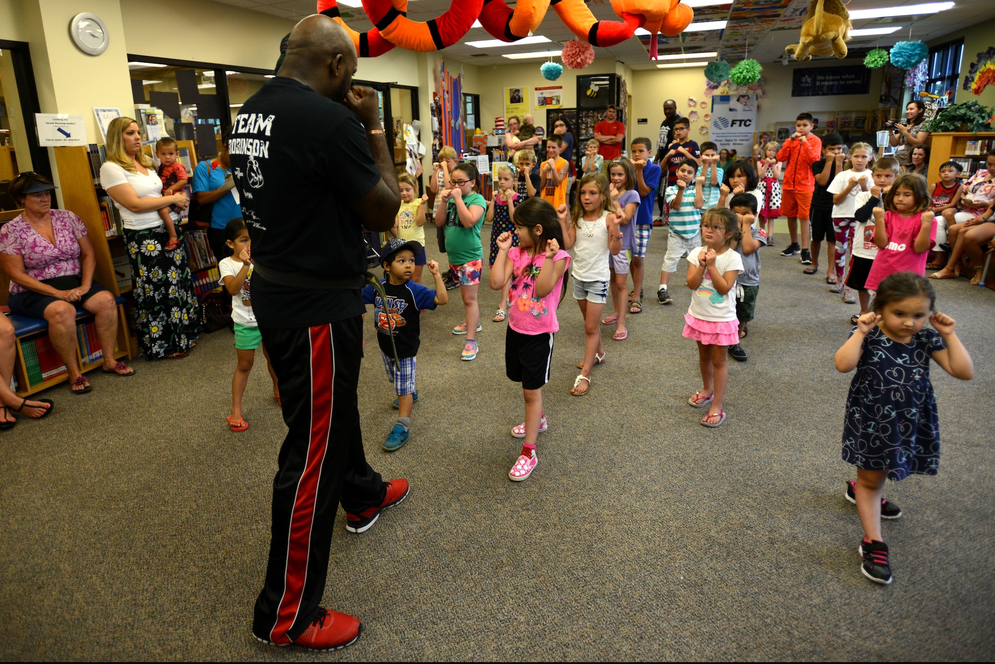 Team Shaw children take part in a martial arts demonstration at the McElveen Information and Learning Center at Shaw Air Force Base, S.C., June 24, 2016. Library staff invited members of Team Robinson MMA to teach basic martial arts and self-defense techniques in support of the summer reading program, which hosts events at the library throughout the summer to foster children’s interest in reading while they are out of school. (U.S. Air Force photo by Airman 1st Class Kelsey Tucker)